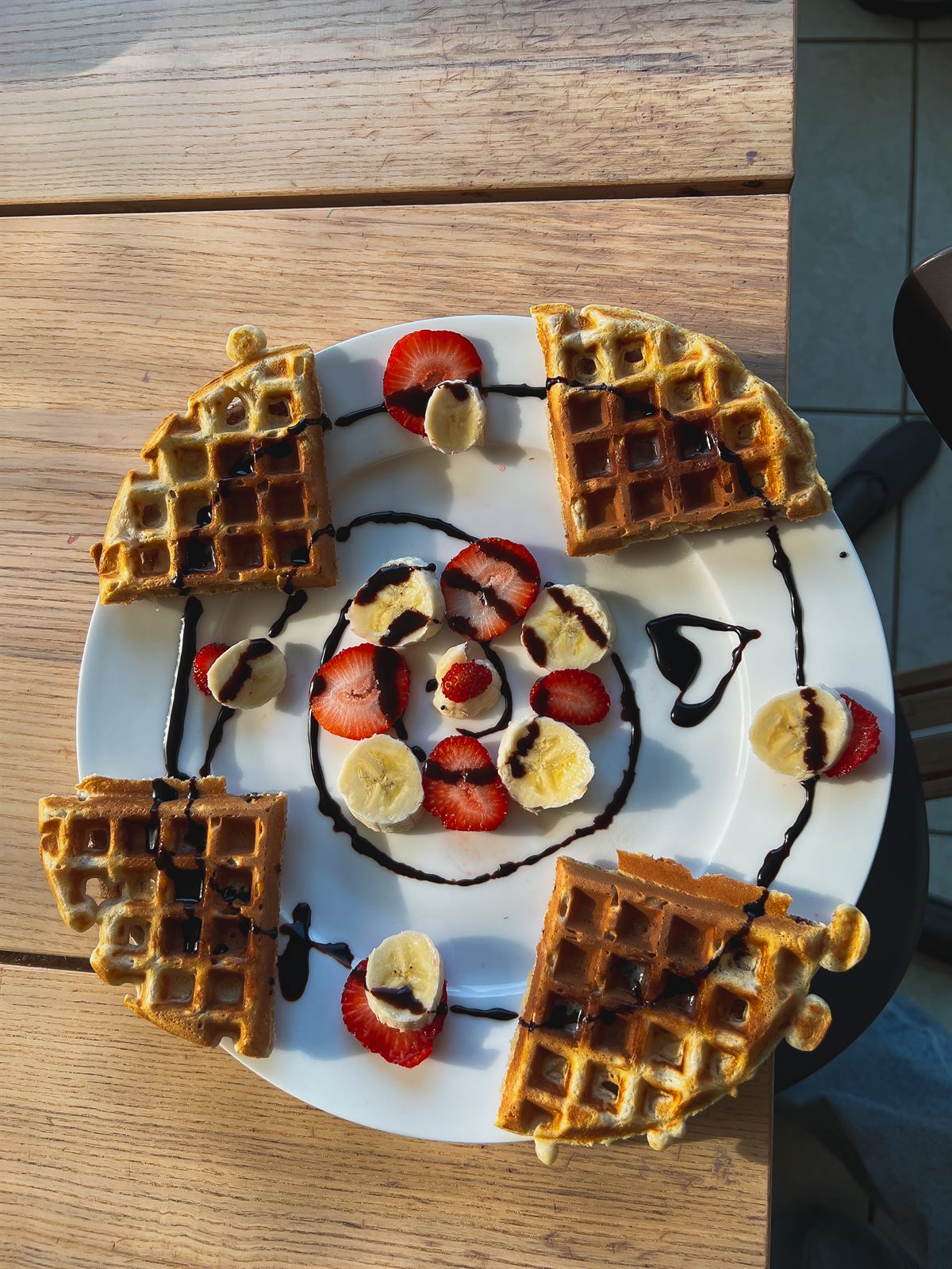 a cute plate of waffles and fruit for my daughter with chocolate swirls and banana and strawbs and little chocolate heart